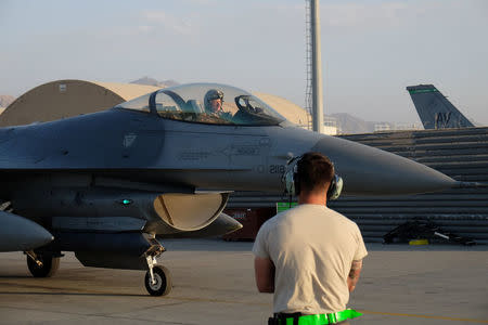 A U.S. Air Force ground crew member prepares to direct the pilot of a F-16 Fighting Falcon aircraft before a mission at Bagram Airfield, Afghanistan August 22, 2017. REUTERS/Josh Smith