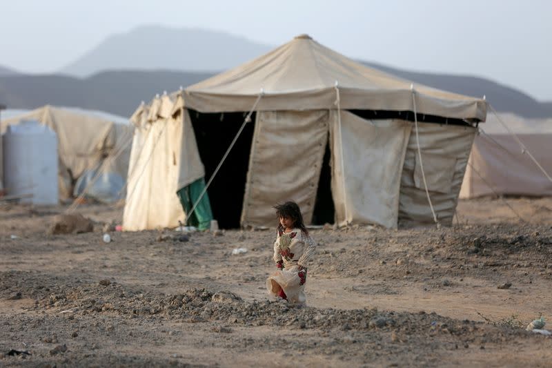 FILE PHOTO: Girl walks past a tent at a camp for internally displaced people (IDPs) in Marib