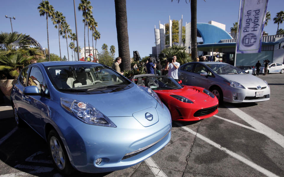 FILE - From left, electric cars from Nissan, Tesla, and Toyota are presented at a news conference in Los Angeles on Dec. 13, 2013. Worldwide demand for lithium was about 350,000 tons (317,517 metric tons) in 2020, but industry estimates project demand will be up to six times greater by 2030. (AP Photo/Nick Ut, File)