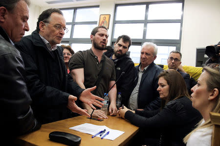 Greek former Energy Minister and leader of the far-left Popular Unity party Panagiotis Lafazanis (2nd L) argues with court officials (R) as protesters entered a courtroom to prevent an auction in Athens, Greece, March 1, 2017. Picture taken March 1, 2017. Costas Baltas/Intimenews via REUTERS