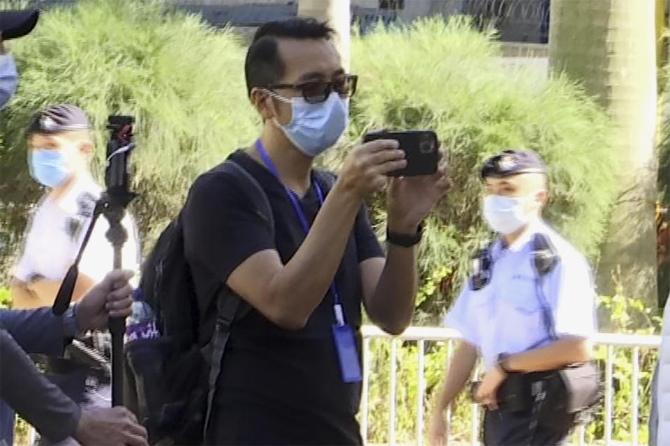 In this photo taken from video, Garry Pang Moon-yuen is seen outside the West Kowloon Court on Nov. 29, 2021. Pang and another Hong Konger were found guilty on a sedition charge on Thursday, Oct. 27, 2022, after they clapped and criticized the judge during a previous trial over a banned Tiananmen Square vigil in the city. (AP Photo/Alice Fung)