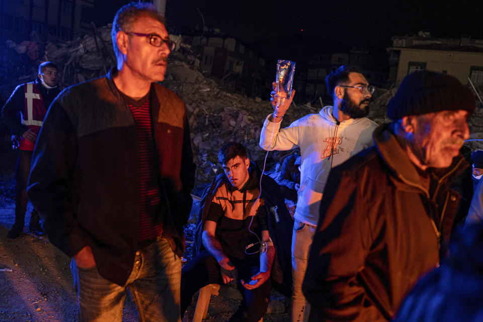 A man gets medical assistance after being injured in the latest earthquake in Hatay, Turkey, Monday, Feb. 20, 2023. A new 6.4 magnitude earthquake on Monday struck parts of Turkey and Syria that were laid waste two weeks ago by a massive quake that killed around 45,000 people. Officials said more buildings collapsed, trapping occupants, and several people were injured in both countries. (Ugur Yildirim/DIA via AP)