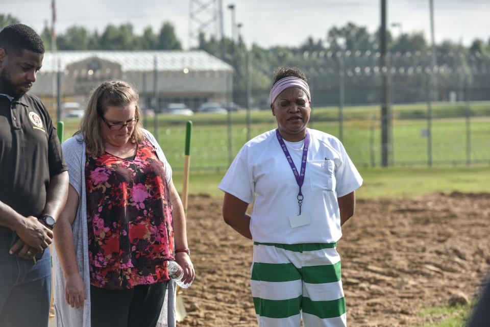 Tara Lyle (right), an incarcarated person, stands with Beth Masters, head of MDOC's women's seminary program, and MDOC Superintendent Derrick Chambers while leading a prayer at the groundbreaking of Central Mississippi Corrections Facility's new interfaith center, stands on site in Pearl, Miss., Friday, August 12, 2022.