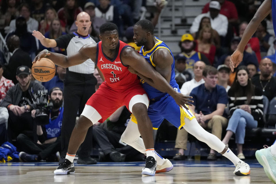 New Orleans Pelicans forward Zion Williamson (1) drives to the basket against Golden State Warriors forward Draymond Green in the first half of an NBA basketball game in New Orleans, Monday, Oct. 30, 2023. (AP Photo/Gerald Herbert)