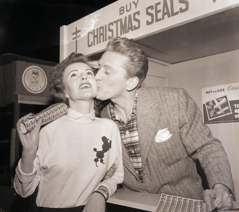 1949: Kirk Douglas plants a kiss at a Christmas event