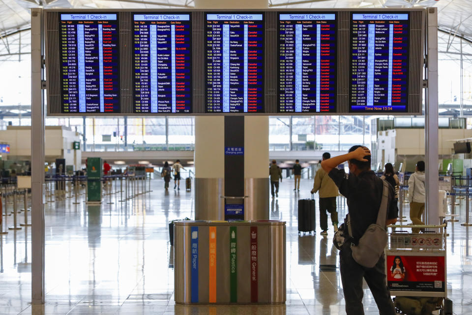 A passenger looks at an information display which shows almost all of the flights have been canceled due to the super typhoon Saola, at Hong Kong International Airport, in Hong Kong, on Friday, Sept. 1, 2023. Hundreds of flights were cancelled as most of Hong Kong and other parts of southern China ground to a near standstill as Super Typhoon Saola edged closer Friday. (AP Photo/Daniel Ceng)