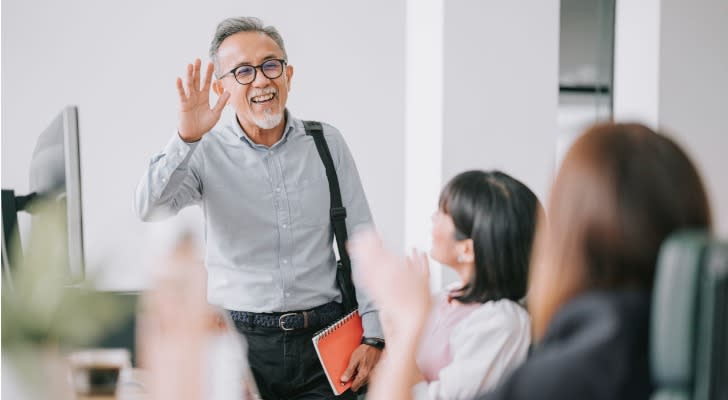 A retiree waves goodbye to coworkers at the company where he works part time. 