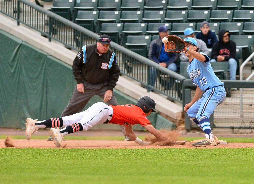 Taunton’s Allen Lewis dives back safely as Franklin’s Evan Raider takes the throw during Saturday’s Division 1 State Championship.