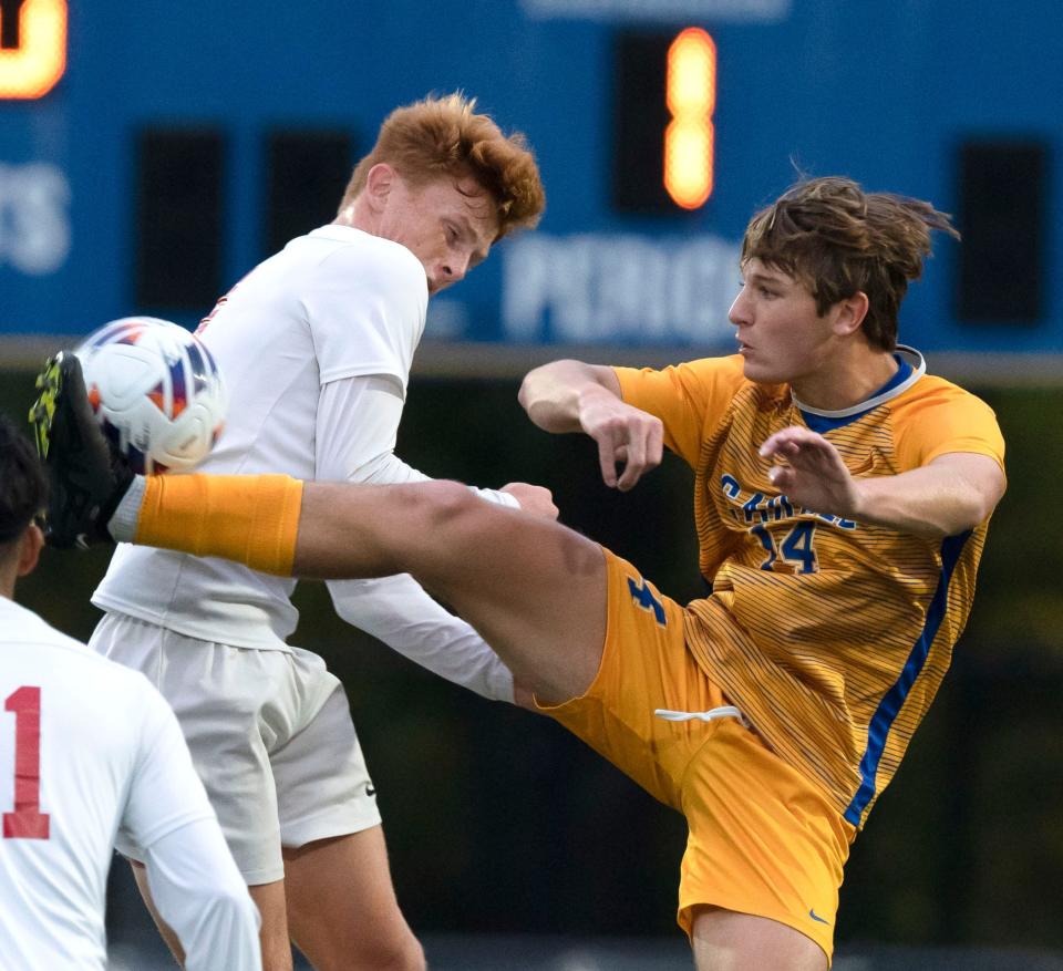 Carmel Greyhound Hayden Warneke (14) and Pike’s Griffin Weaver fight for a ball Tuesday, Oct. 12, 2022, at Carmel High School.