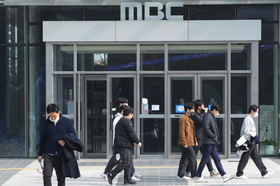 People walk by the headquarters of public broadcaster MBC in Seoul, South Korea, Thursday, Nov. 10, 2022. Journalist organizations say South Korean President Yoon Suk Yeol attacked press freedoms when his office banned one TV broadcaster's crew from the press pool traveling on his presidential plane this week for allegedly biased reporting. (AP Photo/Ahn Young-joon)