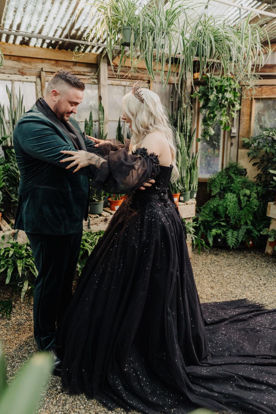 A bride and groom look at each other's outfits on their wedding day.