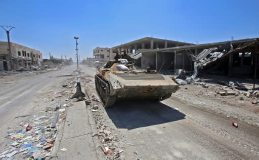 Syrian government soldiers ride in an infantry fighting vehicle in the town of Saida in the west of Daraa province on July 7, 2018