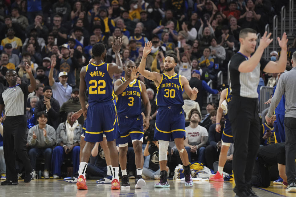 Golden State Warriors guard Stephen Curry (30) celebrates with forward Andrew Wiggins (22) and guard Chris Paul (3) after making a 3-pointer and drawing a foul during the first half of the team's NBA basketball game against the Miami Heat on Thursday, Dec. 28, 2023, in San Francisco. (AP Photo/Loren Elliott)