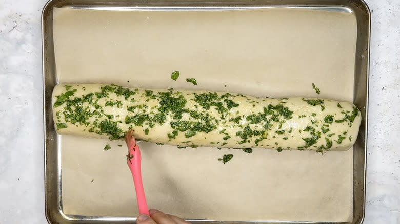 Brushing stromboli with oil and parsley