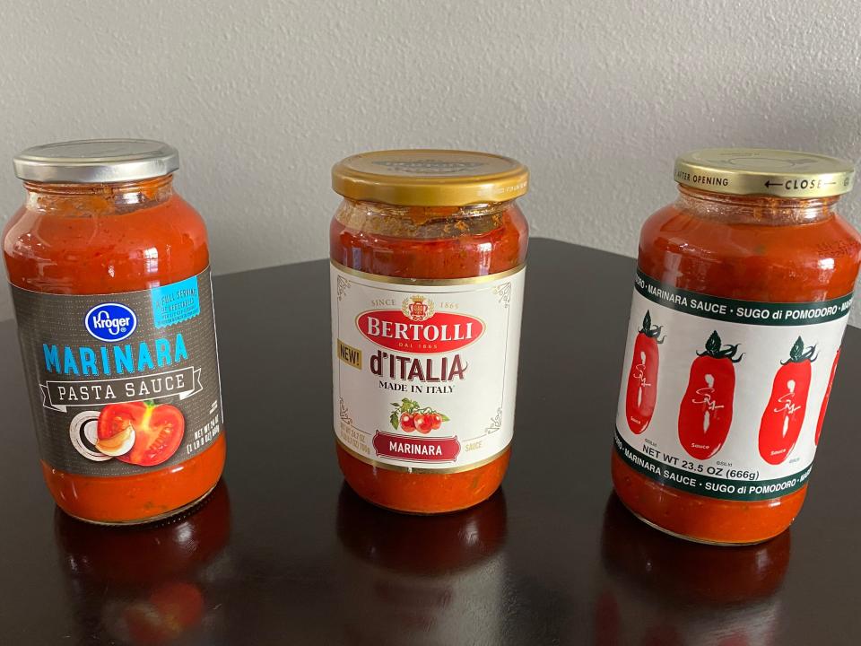 three jars of tomato sauce on a kitchen table