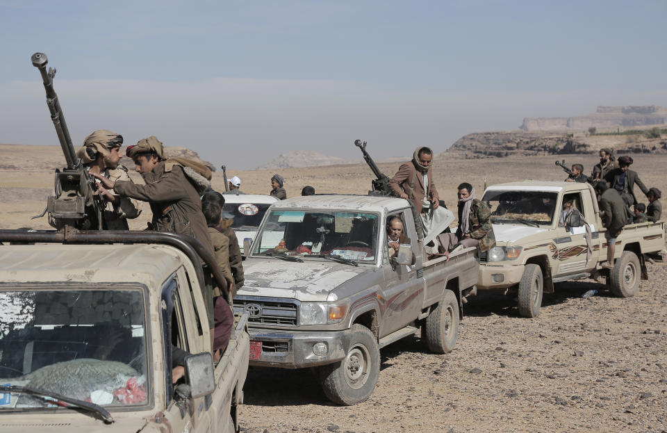 Houthi fighters in trucks armed with weapons.