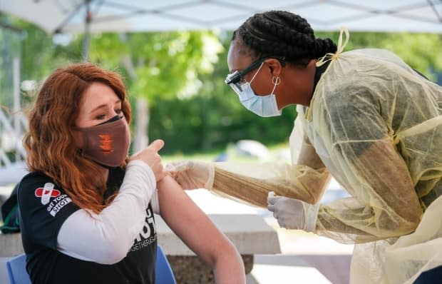 Olympic athlete Clara Hughes receives her second dose of a COVID-19 vaccine at a community vaccination clinic at the Stoney Nakoda First Nation health services centre in Morley, Alta. on June 17, 2021. (Jeff McIntosh/The Canadian Press - image credit)