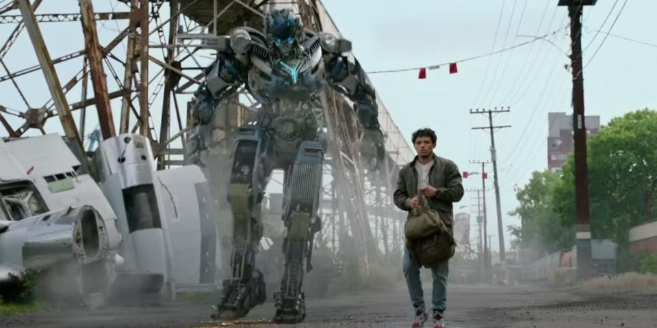 anthony ramos as ramon diaz walks with a transformer in a scene from transformers rise of the beasts