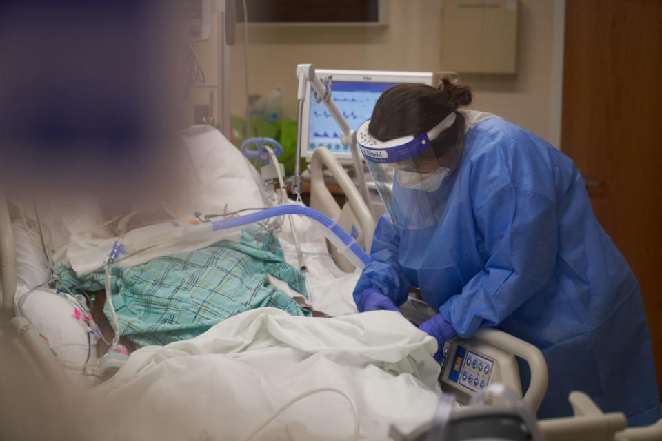 A health care worker treats a COVID-19 patient in the ICU at Hartford Hospital in Hartford, Conn. 