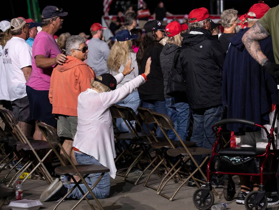 A person kneels as former president Donald Trump speaks during a rally at Wilmington International Airport on Friday, Sept. 23, 2022.