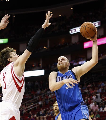 Dallas Mavericks center Chris Kaman (35) shoots a hook shot as Houston Rockets center Omer Asik (3) defends during the first half of an NBA basketball game on Sunday, March 3, 2013, in Houston. (AP Photo/Bob Levey)