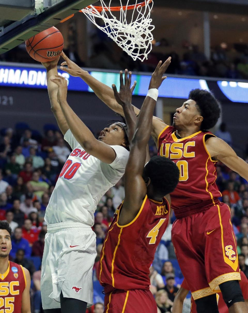 SMU's Ben Moore goes up for a shot as Southern California's Chimezie Metu (4) and Elijah Stewart, right, defend in the first half of a first-round game in the men's NCAA college basketball tournament in Tulsa, Okla., Friday March 17, 2017. (AP Photo/Tony Gutierrez)