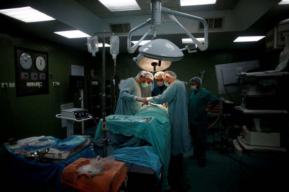 <p>Doctors and medics perform a surgery for Palestinian woman Sadeya al-Shafi, 60, in the operating room at Shifa hospital, Gaza’s largest public medical facility, in Gaza City, March 29, 2017. (Photo: Mohammed Salem/Reuters) </p>