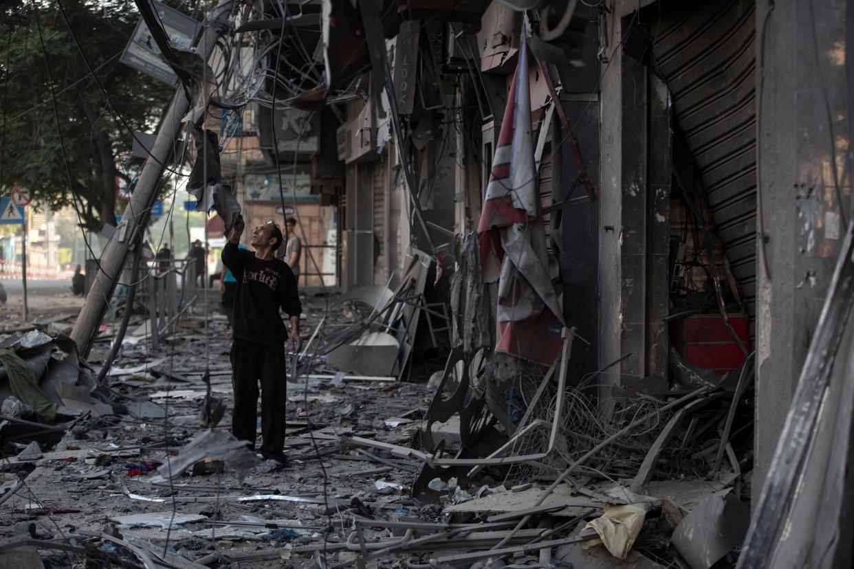 A Palestinian man inspects the damage of his shop following Israeli airstrikes on Gaza City on Thursday, May 13, 2021.