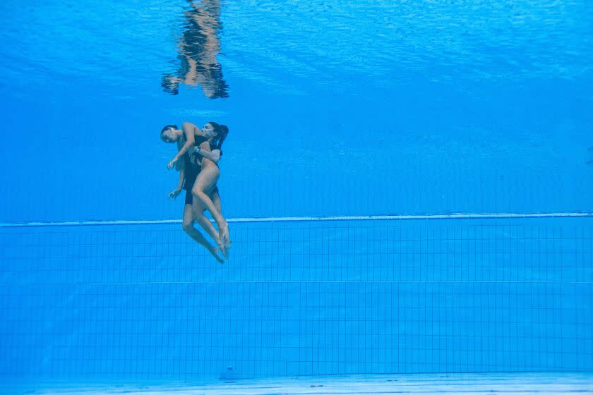 TOPSHOT - USA's Anita Alvarez (L) is recovered from the bottom of the pool by USA's coach Andrea Fuentes (R) after an incident, during the women's solo free artistic swimming finals during the Budapest 2022 World Aquatics Championships at the Alfred Hajos Swimming Complex in Budapest on June 22, 2022. (Photo by Oli SCARFF / AFP) (Photo by OLI SCARFF/AFP via Getty Images)