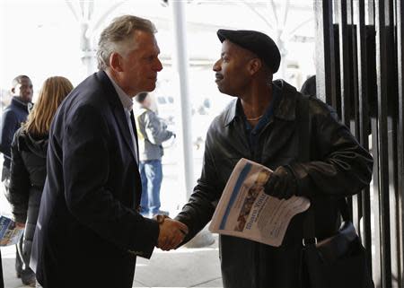 Virginia Democrat gubernatorial candidate Terry McAuliffe (L) greets commuters outside a metro station in Fairfax, Virginia, on election day November 5, 2013. REUTERS/Kevin Lamarque