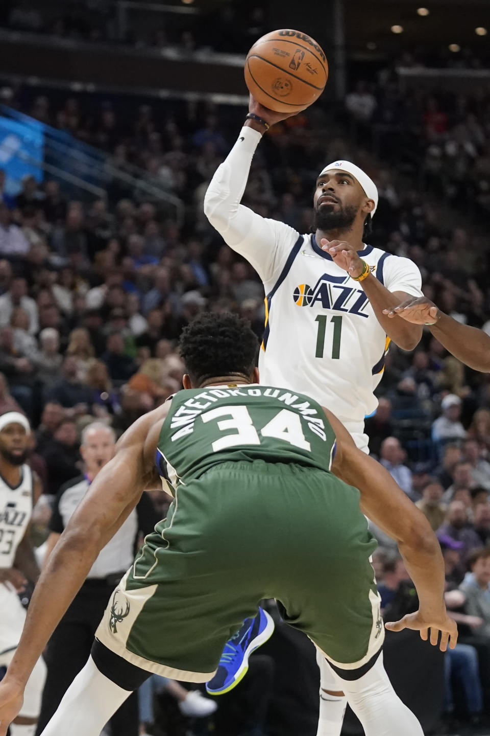 Utah Jazz guard Mike Conley (11) shoots as Milwaukee Bucks forward Giannis Antetokounmpo (34) defends during the first half of an NBA basketball game Monday, March 14, 2022, in Salt Lake City. (AP Photo/Rick Bowmer)