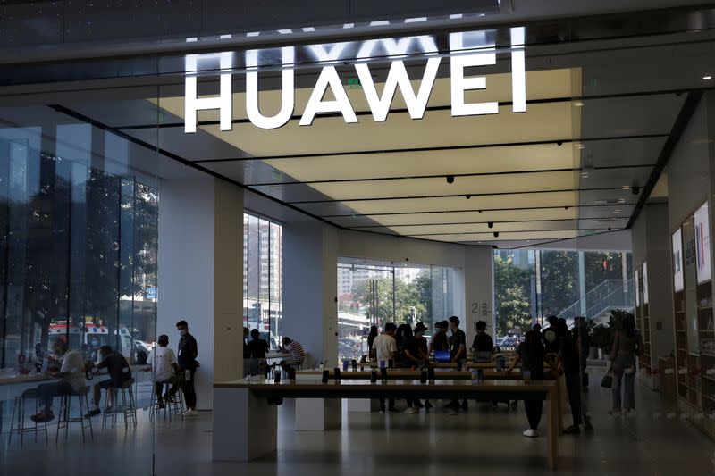 People are seen inside a Huawei store at a shopping mall in Beijing