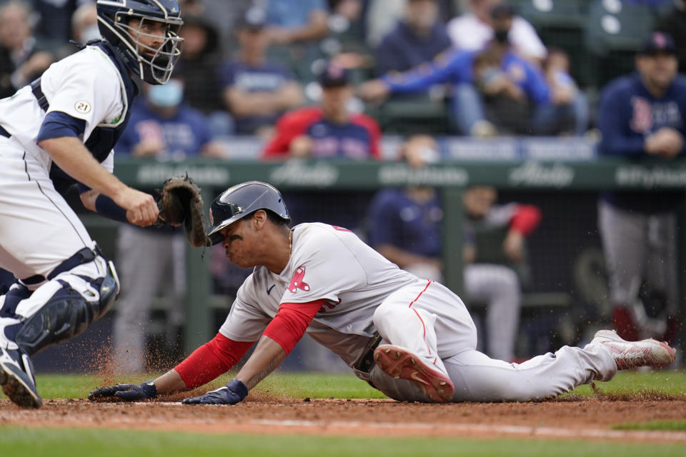 Boston Red Sox's Rafael Devers, right, scores as Seattle Mariners catcher Tom Murphy waits for the ball in the 10th inning of a baseball game Wednesday, Sept. 15, 2021, in Seattle. (AP Photo/Elaine Thompson)