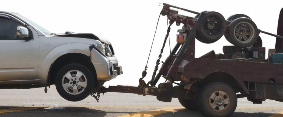 Tow truck delivers the damaged vehicle  isolated on white background, with clipping path