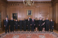 In this image provided by the Supreme Court, President Donald Trump poses for a photo with Associate Justice Brett Kavanaugh in the Justices' Conference Room before a investiture ceremony Thursday, Nov. 8, 2018, at the Supreme Court in Washington. From left are, retired Justice Anthony Kennedy, Associate Justices Neil Gorsuch, Sonia Sotomayor, Stephen Breyer, Clarence Thomas, Chief Justice John Roberts, Jr., President Donald Trump, first lady Melania Trump, Associate Justice Brett Kavanaugh, Ashley Kavanaugh, and Associate Justices Samuel Alito, Jr. and Elena Kagan. (Fred Schilling/Collection of the Supreme Court of the United States via AP)