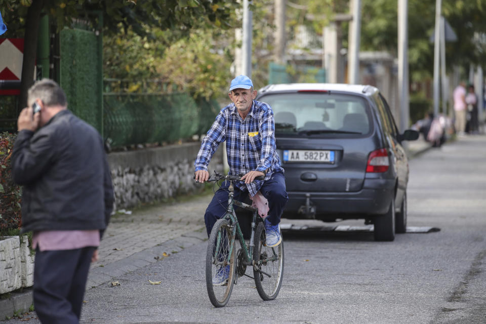A man rides his bicycle in Gjader, northwestern Albania, on Tuesday, Nov. 7, 2023. Italian Premier Giorgia Meloni announced that Albania had agreed to give temporary shelter to thousands of migrants who try to reach Italian shores while their asylum bids are being processed. Albania will offer two facilities, a quarantine area at the port of Shengjin and an accommodation center for those who will be deported at a former military airport in Gjader. (AP Photo/Armando Babani)