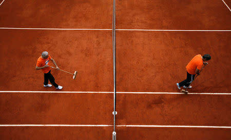 FILE PHOTO: Workers clean the court during a men's singles match between Ernests Gulbis of Latvia and Facundo Bagnis of Argentina at the French Open tennis tournament at the Roland Garros stadium in Paris, France, May 28, 2014. REUTERS/Gonzalo Fuentes/File Photo
