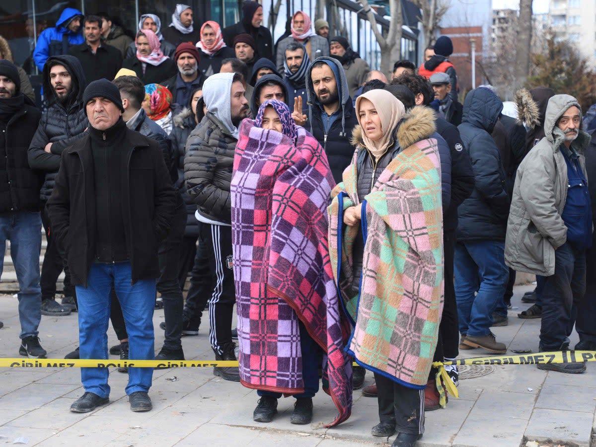 People watch rescuers search for victims and survivors in the rubble (AFP via Getty Images)