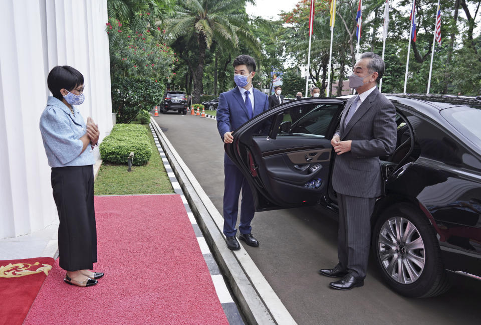 In this photo released by Indonesian Foreign Ministry, Indonesian Foreign Minister Retno Maraud, left, greets her Chinese counterpart Wang Yi upon his arrival for their meeting in Jakarta, Indonesia, Wednesday, Jan. 13, 2021. Wang pledged that China will help Indonesia defeat the coronavirus, including providing vaccines and the strengthen economic cooperation with Indonesia in addition to strengthening cooperation in the health sector in overcoming the COVID-19 pandemic. (Indonesian Foreign Ministry via AP)