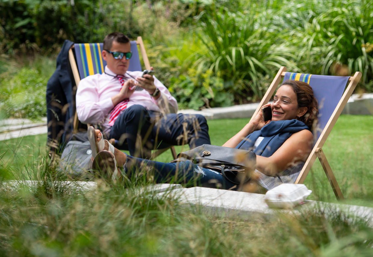 Two people sit on deckchairs near the Lloyds of London building, London, as more hot weather is due to hit the UK this week. (Photo by Dominic Lipinski/PA Images via Getty Images)