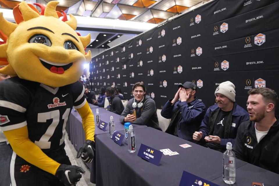 Fiesta Bowl mascot, Spirit, plays blackjack with Michigan Wolverines punter Brad Robbins (91) during Vrbo Fiesta Bowl media day at Camelback Inn in Scottsdale on Dec. 29, 2022.