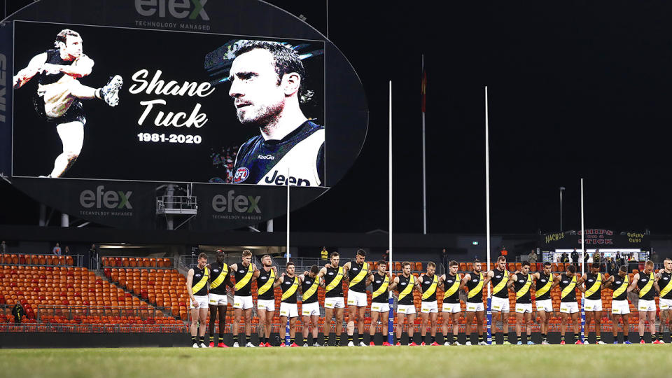 The Richmond Tigers are pictured linking arms for a minute of silence to remember former teammate Shane Tuck.