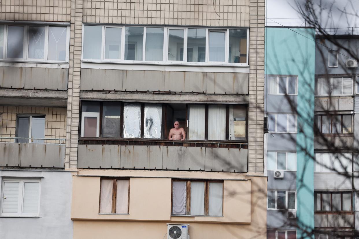 A person looks on from a window at the site of a Russian missile strike in Kyiv today (Reuters)