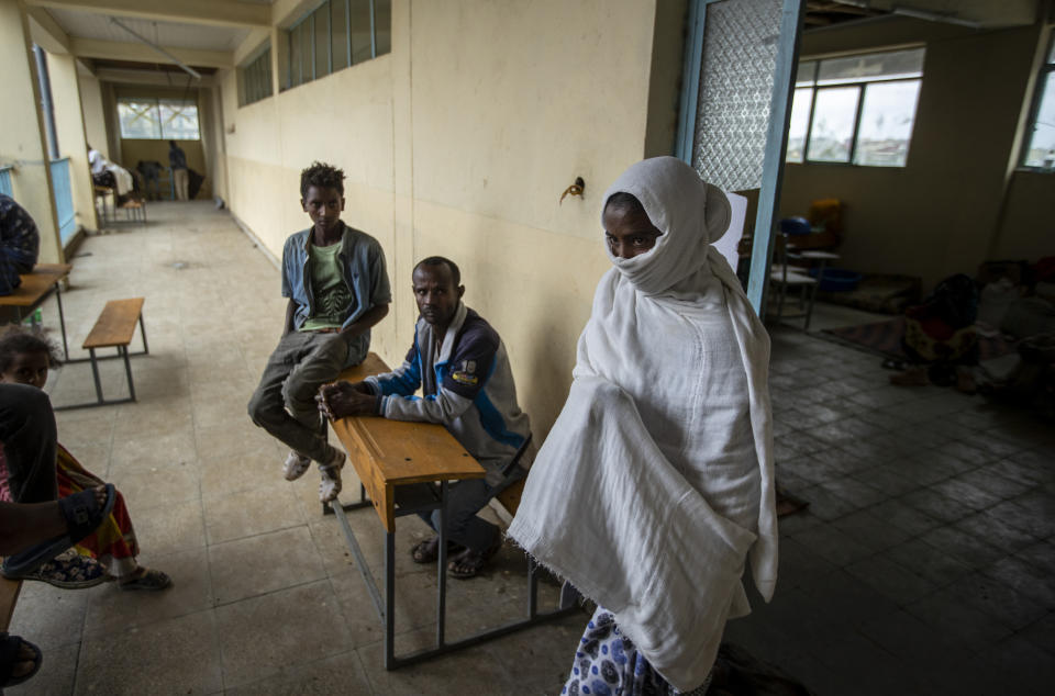 Wegahta Weldie, 21, an accounting student from Mai Kadra who recalled stepping on dead bodies as her family hid in a maize garden and then walked hundreds of kilometers to reach Mekele, walks out of the classroom where she now lives at the Hadnet General Secondary School, which has become a makeshift home to thousands displaced by the conflict, in Mekele, in the Tigray region of northern Ethiopia Wednesday, May 5, 2021. The Tigray conflict has displaced more than 1 million people, the International Organization for Migration reported in April, and the numbers continue to rise. (AP Photo/Ben Curtis)