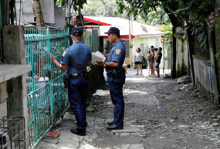 Policemen knock door to door and interview residents during a drug testing operation in Payatas, Quezon City, Metro Manila, Philippines August 23, 2017. REUTERS/Dondi Tawatao