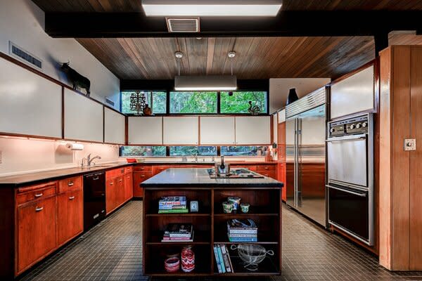 Clerestory windows span across the living areas and continue into the spacious kitchen, which features its original cabinets and soapstone counters.