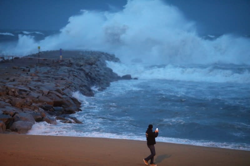 Man takes pictures of the storm "Gloria" on Barceloneta beach, in Barcelona