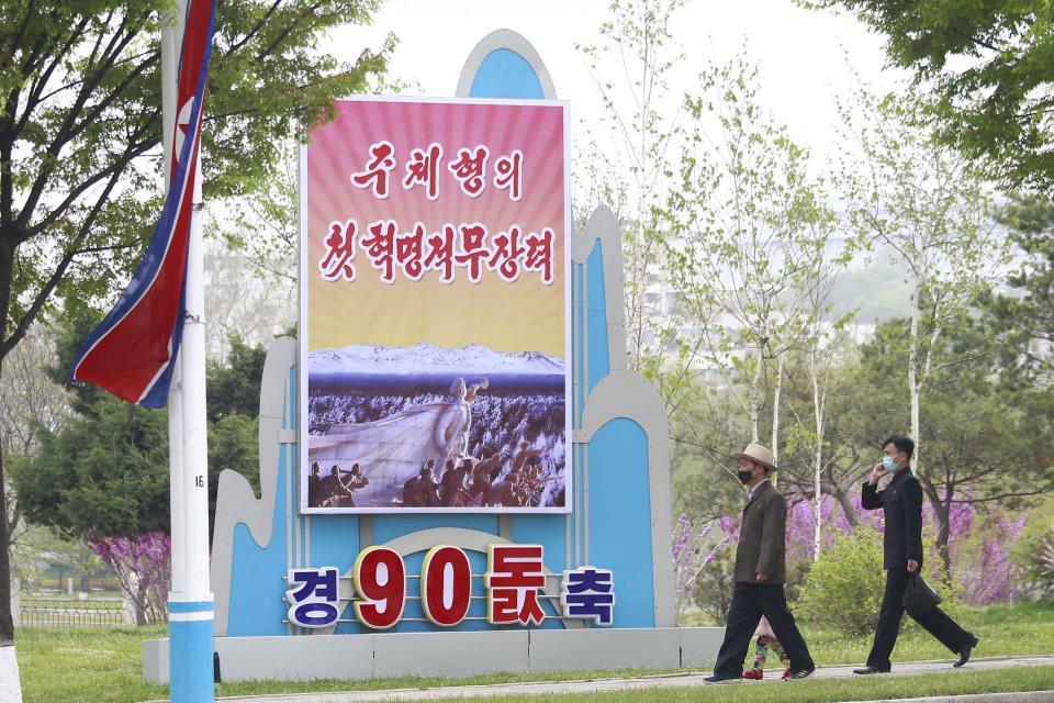 Citizens walk past a celebrative poster displayed on the occasion of 90th founding anniversary of Korean People's Revolutionary Army in Pyongyang, North Korea, Monday, April 25, 2022. Poster reads "The first Juche oriented armed force". (AP Photo/Cha Song Ho)