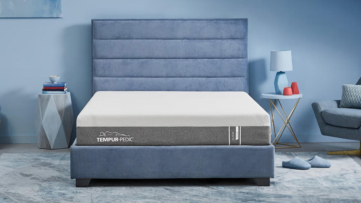  The Tempur-Pedic Tempur Cloud mattress on. blue fabric frame in a blue bedroom. 