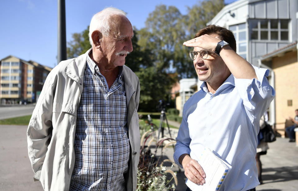 Ulf Kristersson, leader of the Moderate Party, right, speaks with a voter on election day in Strangnas, Sweden, Sunday Sept. 9, 2018. Polls have opened in Sweden's general election in what is expected to be one of the most unpredictable and thrilling political races in Scandinavian country for decades amid heated discussion around top issue immigration. (Erik Simander/TT via AP)